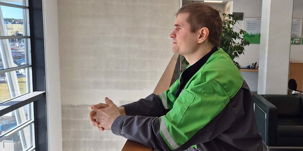 Industrial Design Manager Juhani Salonen leaning on a handrail and looking outside