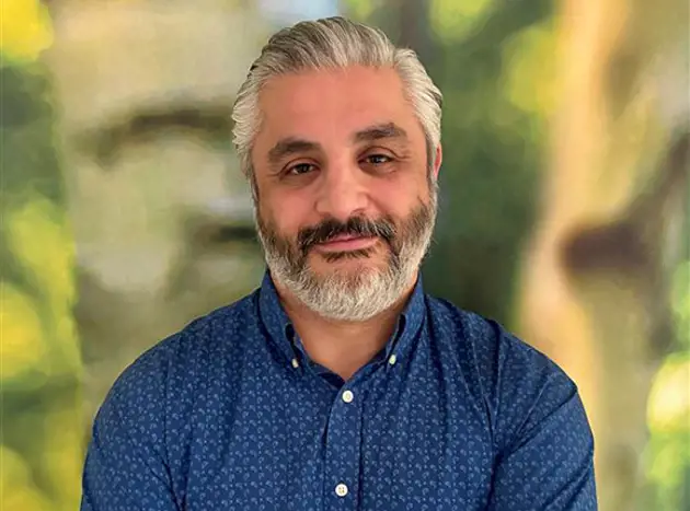 Ali Shahbazi standing in front of a green background. Ali works as a Teamleader, Plant Engineering at Valmet in Sweden. 