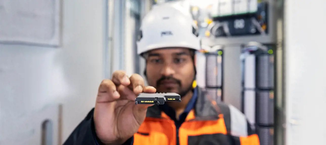 A field technician holding a single-channel I/O card for a distributed control system (DCS)